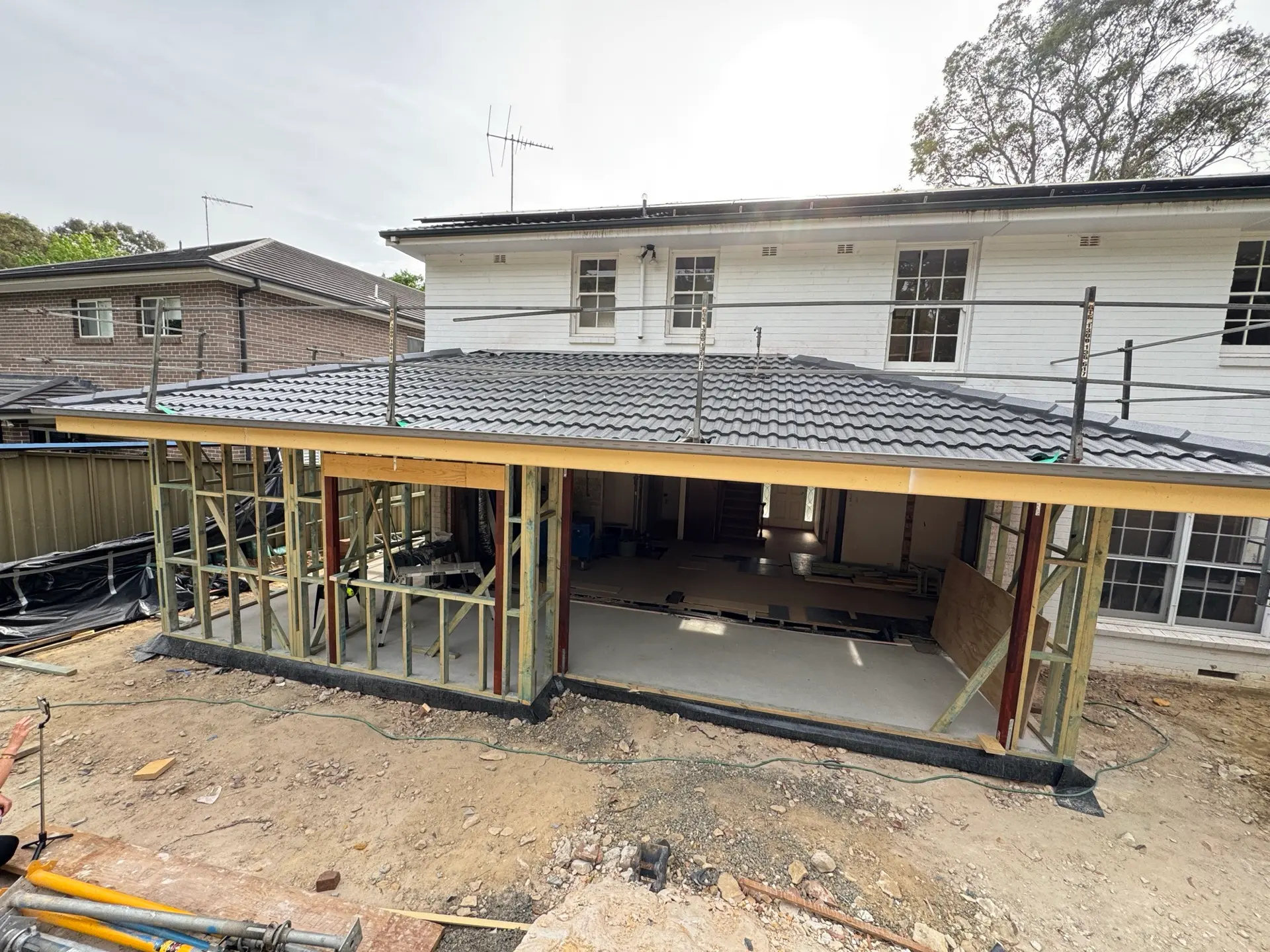 New ground-floor extension framing built beneath the existing upper storey of a Sydney home