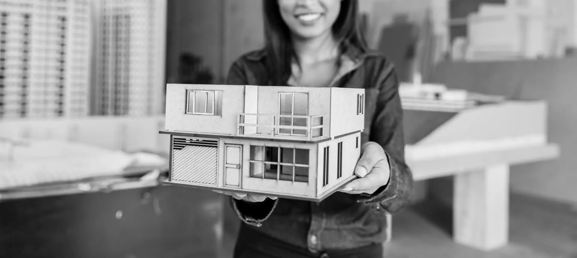 Architectural model of a new two-storey home held up for review