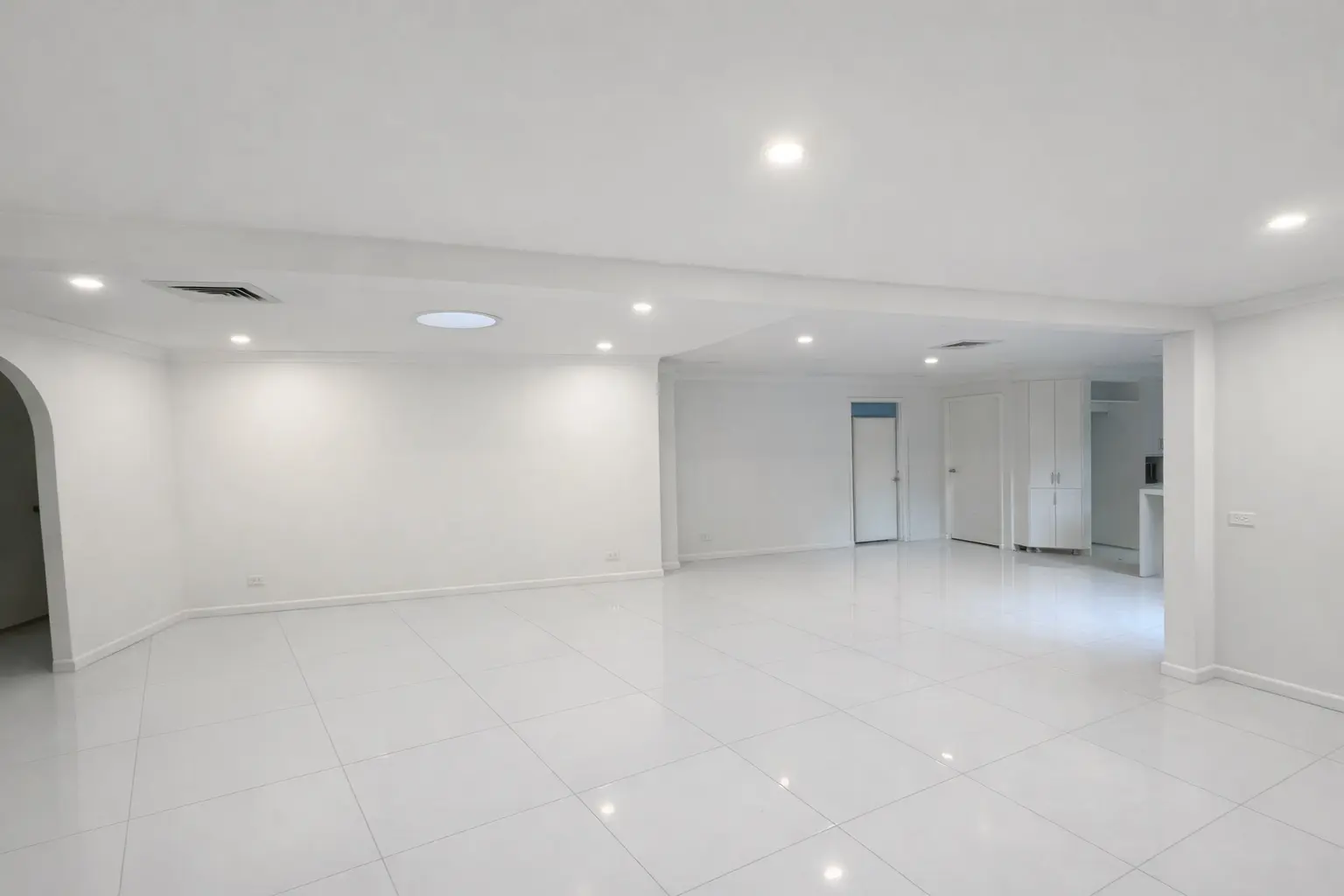 The same living area after the wall removal — a single open span with the new beam concealed in the ceiling